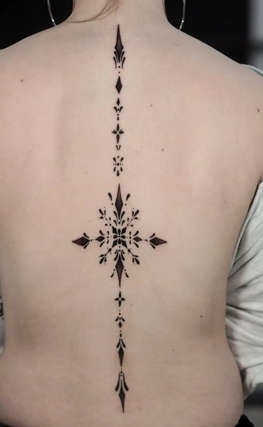 Ornamental spine tattoo with symmetrical patterns and dotwork by Ayah at Omnia Tattoo Melbourne